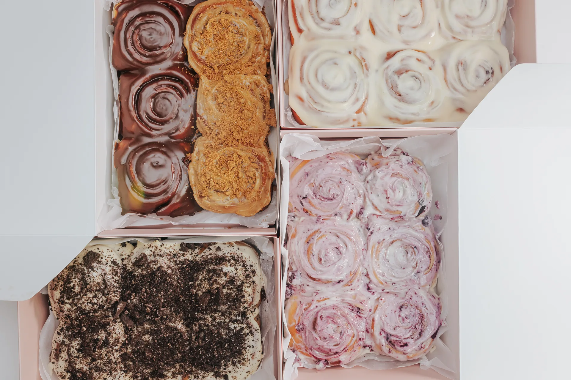Four open boxes of Cimmanon cinnamon rolls in different flavours, ready for a bulk order